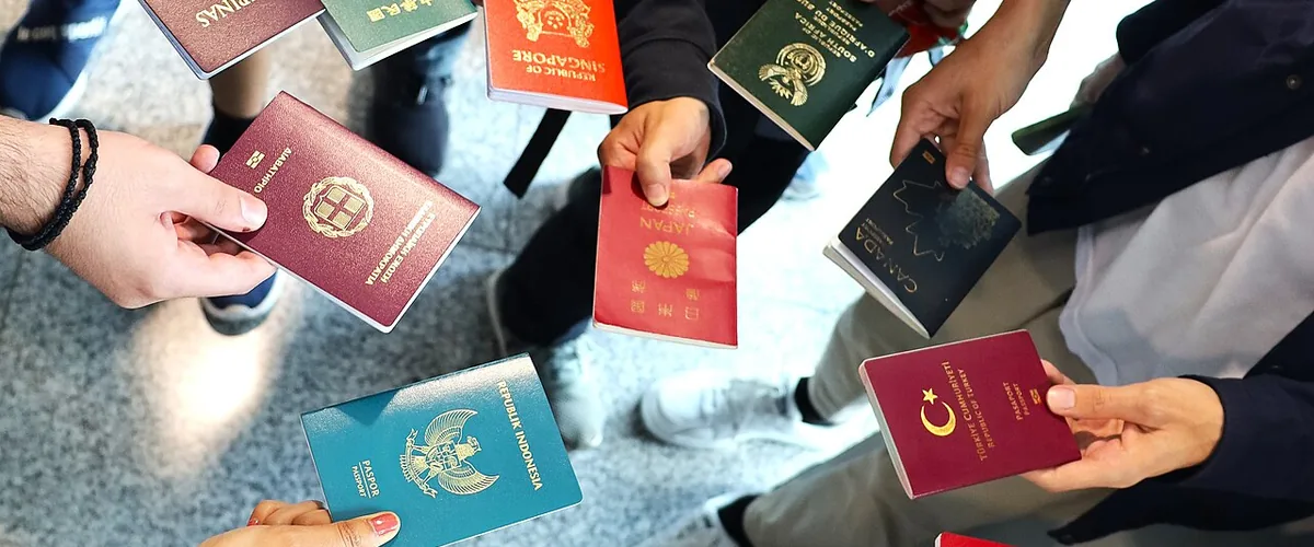 A group of hands holding passports from many different countries
