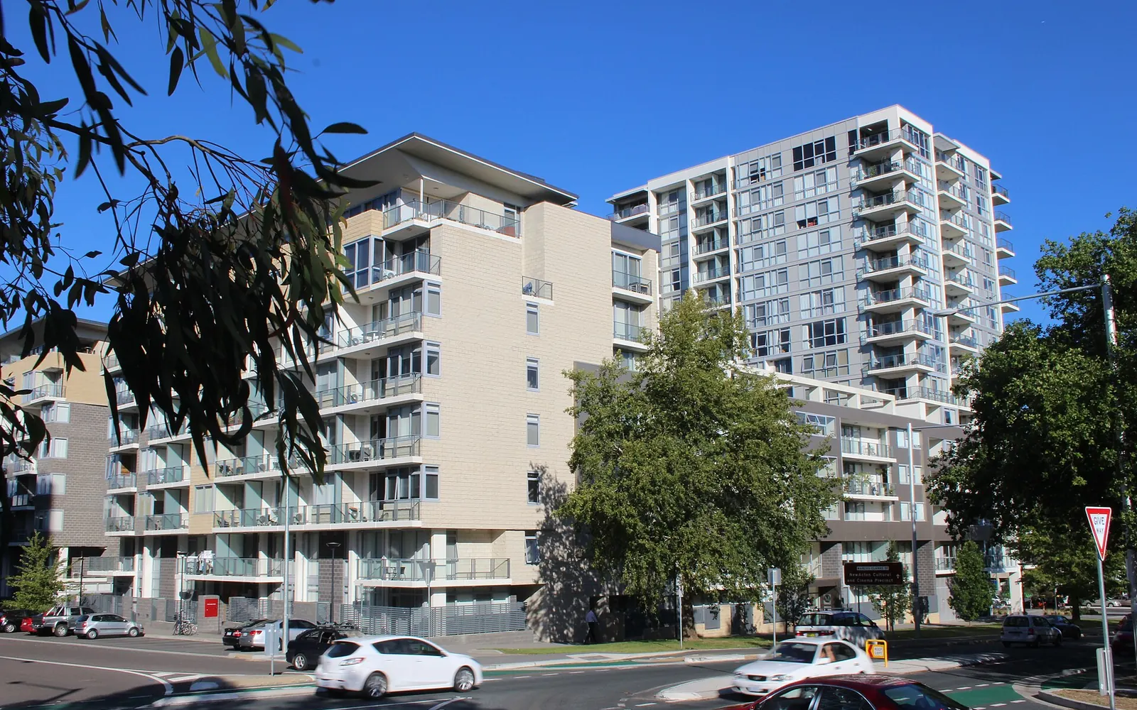 Modern apartment buildings on a city street with parked cars